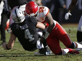 Raiders quarterback Derek Carr is tackled by Chiefs linebacker Dee Ford during first half NFL action in Oakland, Calif., Sunday, Dec. 2, 2018.