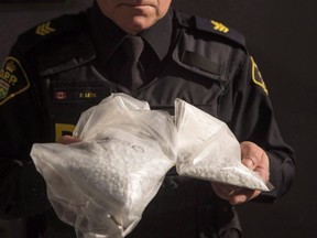 An OPP officer holds a bag of deadly fentanyl pills. Even the dark web is shying away from the drug.