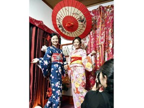 After changing into their kimono, the pair have their picture taken against a traditional Japanese backdrop at Hanaka in the Asakusa district of Tokyo. (Japan News-Yomiuri photo)