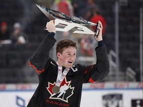 In this Aug. 11, 2018 file photo, Alexis Lafreniere hoists the Hlinka Gretzky Cup in Edmonton. The 17-year-old isTeam Canada's youngest player at the world junior hockey championship.