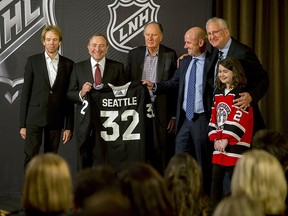NHL commissioner Gary Bettman, centre left, holds a jersey after the NHL Board of Governors announced Seattle as the league's 32nd franchise, Tuesday, Dec. 4, 2018, in Sea Island Ga. Joining Bettman, from left to right, is Jerry Bruckheimer, David Bonderman, David Wright, Tod Leiweke and Washington Wild youth hockey player Jaina Goscinski. (AP Photo/Stephen B. Morton)