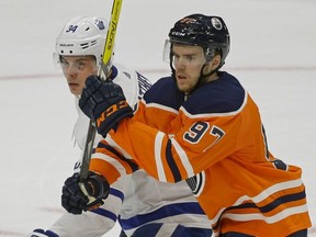 Toronto Maple Leaf Auston Matthews (left) is checked by Edmonton Oiler Connor McDavid (right) during NHL game action in Edmonton on November 30, 2017.