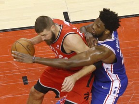 Toronto Raptors' Jonas Valanciunas guarded by Philadelphia 76ers Joel Embiid during the fourth quarter in Toronto, Ont. on Thursday December 6, 2018. Jack Boland/Toronto Sun/Postmedia Network