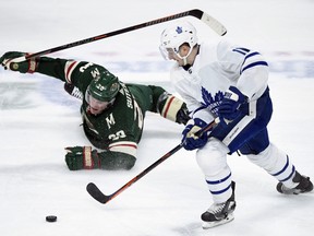 Minnesota Wild defenceman Ryan Suter watches as Toronto Maple Leafs left winger Zach Hyman takes the puck during the third period of an NHL hockey game Dec. 1, 2018, in St. Paul, Minn. Hyman scored an empty net goal on the play. The Maple Leafs won 5-3. (HANNAH FOSLIEN/AP)