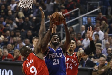 Philadelphia 76ers Joel Embiid C (21) goes up tot the net between Toronto Raptors Serge Ibaka PF (9) and teammate Danny Green SG (14) during the first quarter in Toronto, Ont. on Thursday December 6, 2018. Jack Boland/Toronto Sun/Postmedia Network