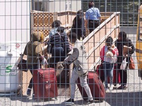 A group of asylum seekers arrive at the temporary housing facilities at the border crossing Wednesday May 9, 2018 in St. Bernard-de-Lacolle, Que.