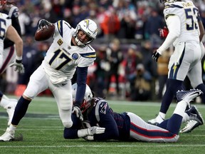 Philip Rivers #17 of the Los Angeles Chargers is tackled by Adrian Clayborn #94 of the New England Patriots during the fourth quater in the AFC Divisional Playoff Game at Gillette Stadium on January 13, 2019 in Foxborough, Massachusetts.