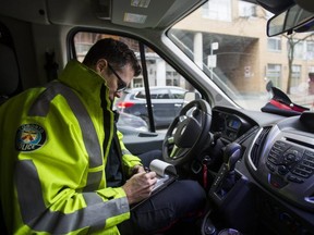 Const. Bryan Brett writes a ticket for distracted driving along Richmond St. on Jan. 14, 2019.(Ernest Doroszuk, Toronto Sun)