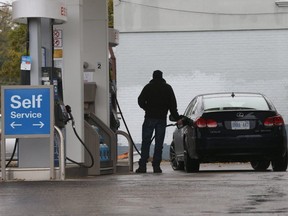 A driver fills up in the Victoria Park and St. Clair Aves. area. (Jack Boland, Toronto Sun)