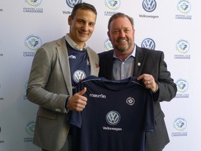 Canadian Premier League commissioner David Clanachan (right) and Volkswagen Group Canada president Daniel Weissland hold up a soccer jersey at a CPL event on Tuesday. (THE CANADIAN PRESS)
