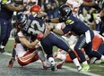 Running back Chris Carson (centre), quarterback Russell Wilson (right) and the Seattle Seahawks went 6-1 after starting the season at 4-5 to make this year’s playoffs. They face the Cowboys on Saturday night. (AP)