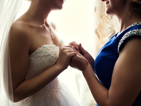 Bride on wedding day holding her mother's hands. Concept of relationship between moms and daughters
