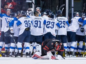 Canada goaltender Michael DiPietro, front, kneels on the ice after Finland defeated Canada during overtime quarter-final IIHF world junior hockey championship action in Vancouver on Wednesday, Jan. 2, 2019.