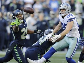In this Sept. 23, 2018, file photo, Seattle Seahawks free safety Earl Thomas, left, reaches for a pass he intercepted that was intended for Dallas Cowboys tight end Blake Jarwin, right, as Seahawks' Bobby Wagner, center, looks on during the second half of an NFL football game, in Seattle.