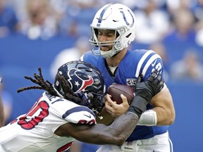 In this Sept. 30, 2018, file photo, Indianapolis Colts quarterback Andrew Luck (12) is sacked by Houston Texans' Jadeveon Clowney (90) during the first half of an NFL football game, in Indianapolis.
