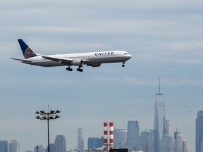 A United Continental airplane prepares for landing as the New York City skyline stands in the background at Newark Liberty International Airport in 2017. Bloomberg photo by Timothy Fadek.