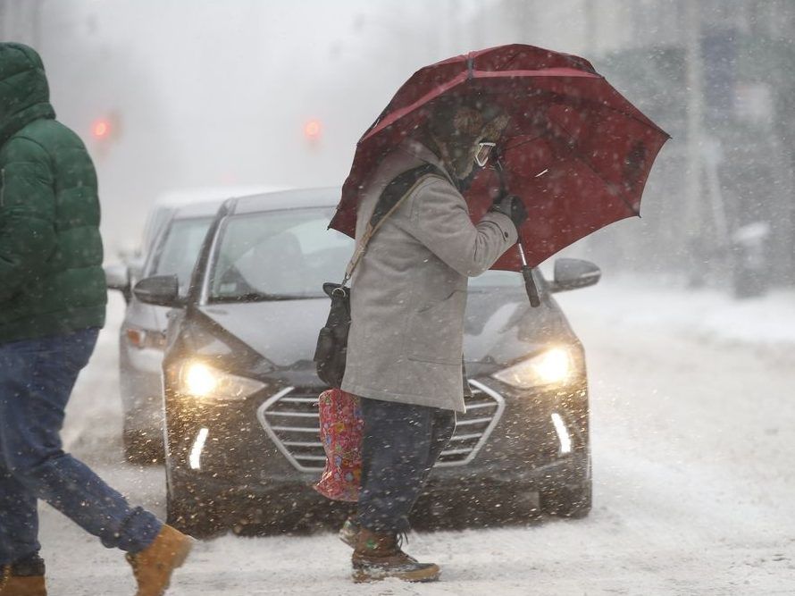 A man uses a huge umbrellas and ski googles to brave the weather at Yonge and Wellesley St. E. in Toronto on Jan. 28, 2019.