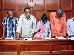 (L-R) Osman Ibrahim, Canadian national Guleid Abdihakim, Gladys Kaari Justus, Oliver Muthee and Joel Nganga, six suspects arraigned in court in connection with an Islamist attack on a Nairobi hotel complex that left 21 dead, stand in the courthouse of Nairobi, on January 18, 2019.  ( STRINGER / AFP)