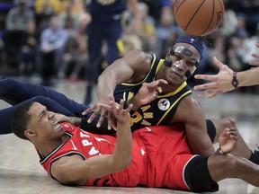 Indiana Pacers center Myles Turner (33) and Toronto Raptors guard Patrick McCaw (1) hit the floor while scrambling for the ball during the second half of an NBA basketball game in Indianapolis, Wednesday, Jan. 23, 2019. The Pacers won 110-106. (AP Photo/Michael Conroy)