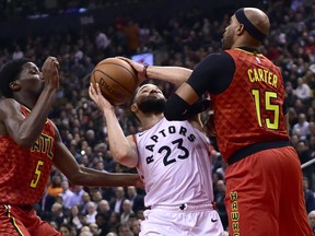 Toronto Raptors guard Fred VanVleet (23) gets fouled by Atlanta Hawks forward Vince Carter (15) as teammate Daniel Hamilton (5) looks on during first half NBA basketball action in Toronto on Tuesday, Jan. 8, 2019. THE CANADIAN PRESS/Frank Gunn ORG XMIT: FNG509