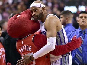 Sacramento Kings guard Vince Carter (15) embraces The Raptor, the Toronto Raptors mascot during second half NBA basketball action in Toronto on Sunday, December 17, 2017. THE CANADIAN PRESS/Frank Gunn ORG XMIT: FNG507