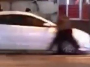 A man clings to the roof of a car in video obtained by CTV News Toronto.