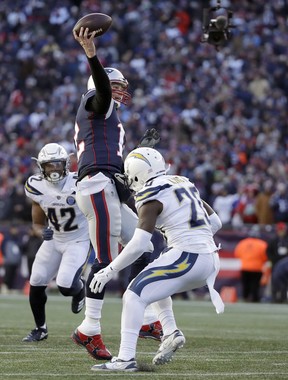New England Patriots quarterback Tom Brady passes between Los Angeles Chargers linebacker Uchenna Nwosu (42) and defensive back Desmond King (20) during the second half of an NFL divisional playoff football game, Sunday, Jan. 13, 2019, in Foxborough, Mass. (AP Photo/Elise Amendola)