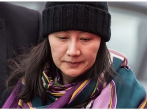 Huawei chief financial officer Meng Wanzhou, talks with a member of her private security detail after they went into the wrong building while arriving at a parole office, in Vancouver, on Dec. 12, 2018.