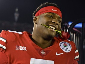Ohio State quarterback Dwayne Haskins smiles, with a rose between his teeth, after Ohio State defeated Washington 28-23 in the Rose Bowl in Pasadena, Calif., Tuesday, Jan. 1, 2019.