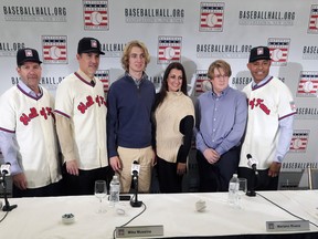 Baseball Hall of Fame inductees Edgar Martinez (left), Mike Mussina, and Mariano Rivera (right) pose for photos with Braden Halladay (third from left), Brandy Halladay (centre) and Ryan Halladay after a news conference on Wednesday in New York. Brandy says her late husband Roy will enter Cooperstown with a blank hat. (AP PHOTO)