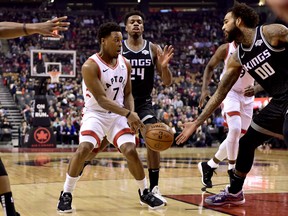 Raptors guard Kyle Lowry (7) makes a pass under pressure from Sacramento Kings guard Buddy Hield (24) and teammate Willie Cauley-Stein on Tuesday night in Toronto. (Frank Gunn/The Canadian Press)