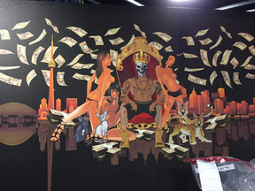 A giant portrait of a bare-chested and crowned Jahmal Richardson sitting on a throne surrounded by a bevy of bare-chested women and fluttering $100 bills.