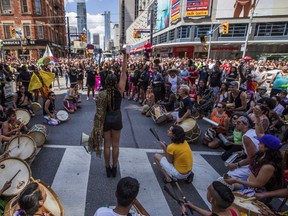 People from the Black Lives Matter sit on the ground to halt the annual Pride Parade, in Toronto on Sunday, July 3, 2016. (THE CANADIAN PRESS/Mark Blinch)