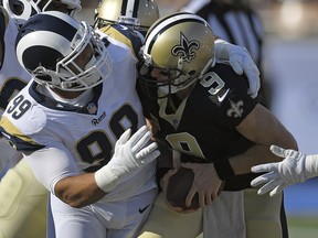In this Nov. 26, 2017, file photo, New Orleans Saints quarterback Drew Brees, right, gets sacked by Los Angeles Rams defensive end Aaron Donald in Los Angeles. (AP Photo/Mark J. Terrill, File)