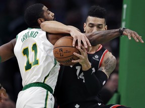 Celtics guard Kyrie Irving (left) and Raptors’ Danny Green get tangled up as they compete for the ball in Boston on Wednesday.  AP