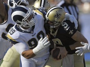 In this Nov. 26, 2017, file photo, Saints quarterback Drew Brees, right, gets sacked by Rams defensive end Aaron Donald during NFL action in Los Angeles.