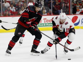 Making his Carolina Hurricanes debut, Nino Niederreiter (21) battles for the puck with Ottawa Senators' Zack Smith (15) during the first period of an NHL hockey game Friday, Jan. 18, 2019, in Raleigh, N.C. (AP Photo/Karl B DeBlaker)