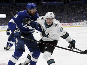 Tampa Bay Lightning defenseman Braydon Coburn and San Jose Sharks right wing Joonas Donskoi fight for the puck during the first period of an NHL hockey game Saturday, Jan. 19, 2019, in Tampa, Fla. (AP Photo/Jason Behnken)