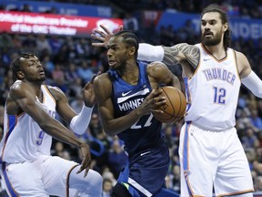 Minnesota Timberwolves forward Andrew Wiggins (22) drives between Oklahoma City Thunder forward Jerami Grant (9) and centre Steven Adams (12) in Oklahoma City, Tuesday, Jan. 8, 2019. (AP Photo/Sue Ogrocki)