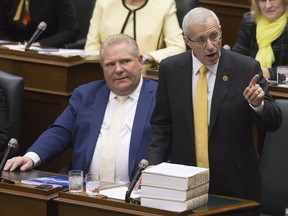 Vic Fedeli rises in the legislature at Queen's Park this afternoon, to read the Economic Outlook For Ontario, as his fellow MPPs wear yellow to show their support for him.  Toronto, Ont. on Thursday November 15, 2018. Stan Behal/Toronto Sun/Postmedia Network ORG XMIT: POS1811151415521194