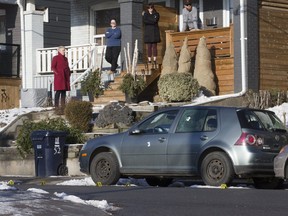 Councillor Paula Fletcher speaks to residents as bullet holes can be seen in a car and evidence markers on the ground after a shooting on Walpole Ave. on Friday, Jan. 4, 2019. (Stan Behal/Toronto Sun)