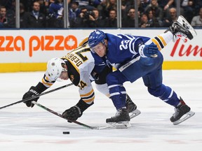 Jake DeBrusk of the Boston Bruins (left) battles against Travis Dermott of the  Maple Leafs on Saturday night at Scotiabank Arena. (GETTY IMAGES)