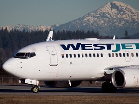 File photo of a Westjet Boeing plane arriving at Vancouver International Airport in Richmond, B.C., on Feb. 3, 2014. (THE CANADIAN PRESS/Darryl Dyck)