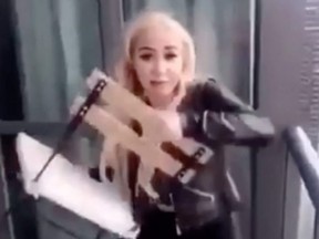 A woman is filmed throwing a deck chair from a highrise condo balcony towards the Gardiner Expressway in Toronto. (Screengrab)