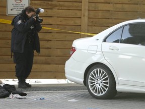 A Toronto Police officer takes video and photos outside a west-end condo where a woman was shot on Feb. 10, 2019. (Jack Boland, Toronto Sun)
