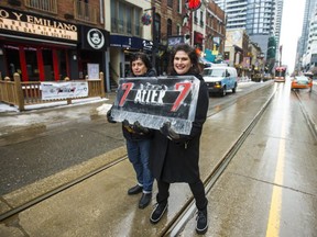 Joanna Dionisopoulos, manager of Kit Kat Italian Bar & Grill (left) and Ashley Tollis, general manager of N'Awlins Jazz Bar, hold one of several ice sculptures being used for a promotion designed to bring customers back to King St. W. (Ernest Doroszuk, Toronto Sun)
