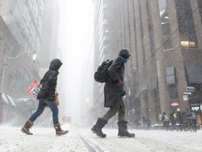 Pedestrians are pictured as they brave blowing snow in downtown Toronto on Jan. 28, 2019. (The Canadian Press)