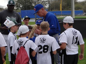 Roving minor-league pitching coach Rick Langford signs autographs for some young ball players in Dunedin. Eddie Michels, photo
