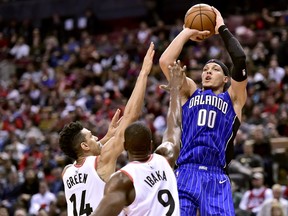 Raptors' Danny Green and Serge Ibaka try to defend a shot by Orlando Magic forward Aaron Gordon during Sunday's game. (THE CANADIAN PRESS)