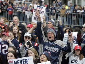 Fans wait for the New England Patriots parade to through downtown Boston, Feb. 5, 2019, to celebrate their win over the Los Angeles Rams in Sunday's NFL Super Bowl 53 football game in Atlanta. (AP Photo/Steven Senne)